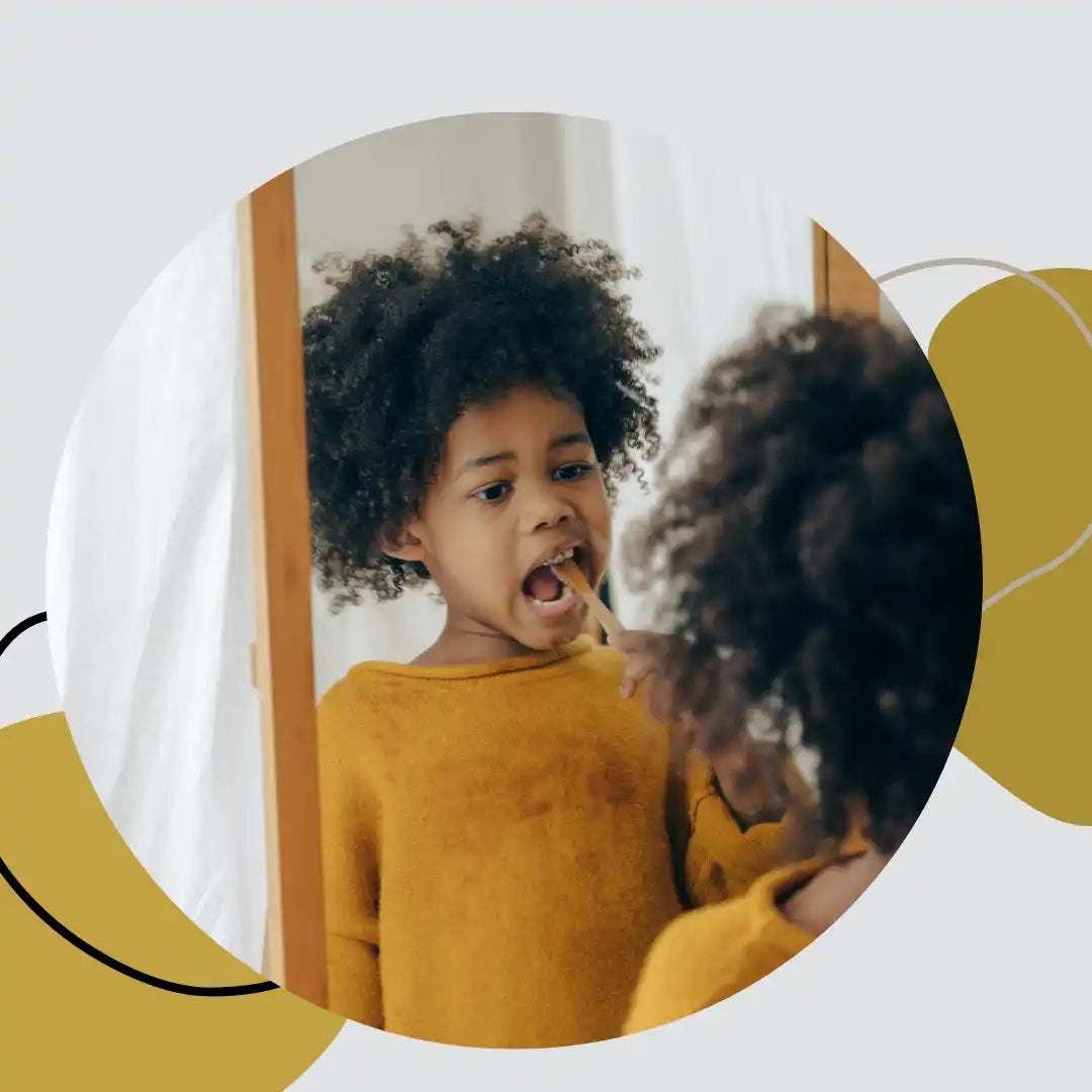 A child wearing a yellow sweater with natural curly hair expressing excitement.