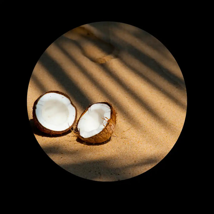 Split coconut with white flesh exposed.